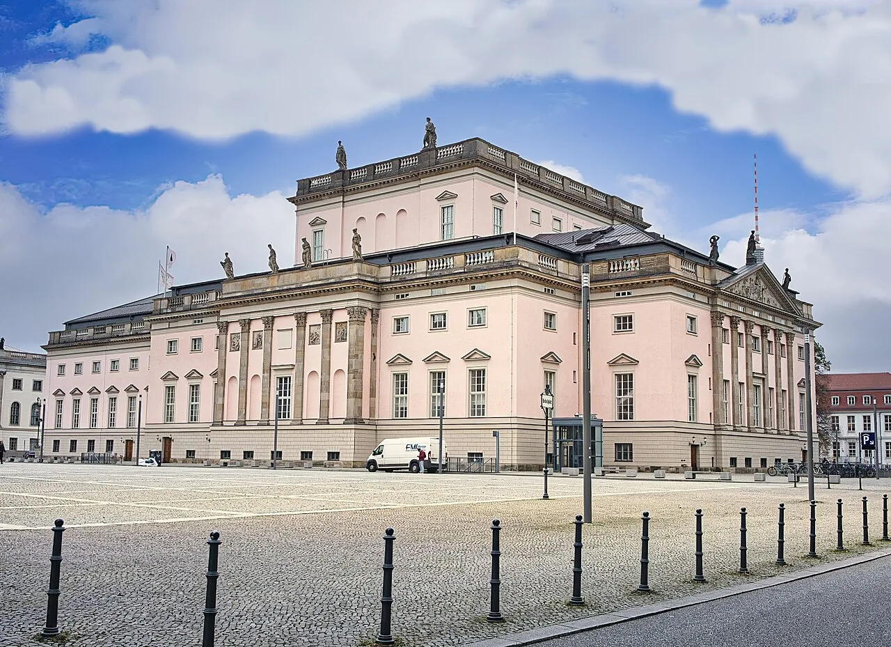 De Unter den Linden boulevard in Berlijn met rijzige lindebomen en het Brandenburger Tor in het verschiet